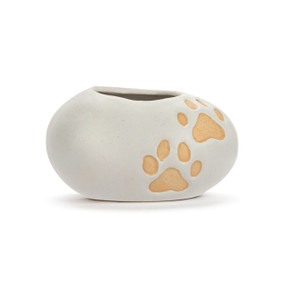 A mini cream ceramic planter. It has two tan paw prints.