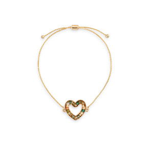 An adjustable gold chain bracelet with a heart shaped charm filled with small green stones.