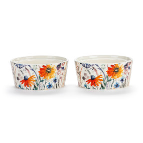 Two white ceramic ramekins with a meadow flower pattern on the outside, displayed at an angle to show the lip on the inside rim allowing them to stack.