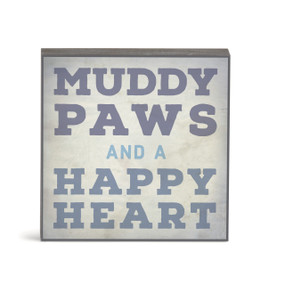 A small square gray wall art with the saying "Muddy paws and a happy heart".