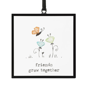 A small square suncatcher with a butterfly and flowers made out of small colored stones and the saying "friends grow together".
