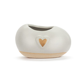 A mini cream ceramic planter. It has a raised gold heart on the front.