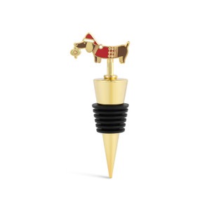 A gold and black bottle stopper with a dog wearing a red sweater and stocking cap and holding an ornament in its mouth.