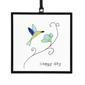A small square suncatcher with a hummingbird and flower made out of small colored stones and the saying "happy day".