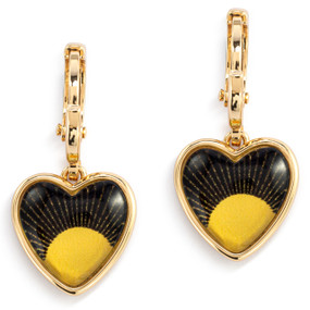 A pair of gold dangling earrings with a heart shaped charm and an illustration of a yellow sun on a black background inside.