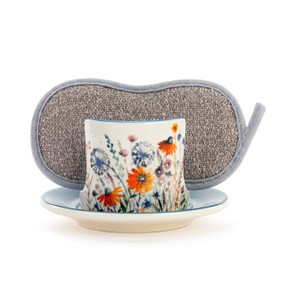 A cream ceramic soap dish with meadow wildflowers, and a gray sponge in the open slot.