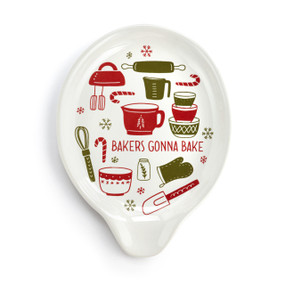 Top down view of a white ceramic spoon rest with red and green illustrations of baking tools and the saying "Bakers Gonna Bake".