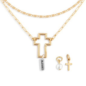 A gold chain necklace with an open cross that is used to place other charms on.