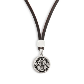 Detailed image of the charm on a men's brown leather adjustable necklace with a round silver charm of a cross.