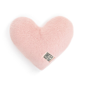 A pink heart shaped weighted pillow with a fabric tag that says "kindness".