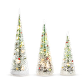 A set of three decorated and lit bottlebrush trees inside clear glass. They are all a different height.
