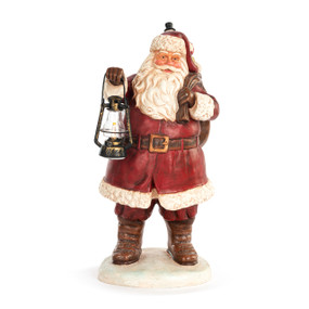 An old fashioned Santa figurine with him holding a sack of toys over one shoulder and a lantern that lights up in the other hand.