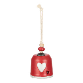 A mini red bell with a white heart on the front. There are beads and a metal token at the top of the bell.