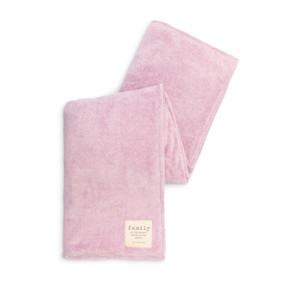 A large soft pink mega blanket with a cream fabric tag in the lower right corner.