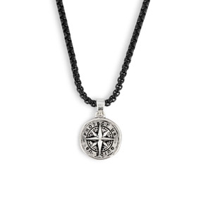 Detail view of the charm on a men's black adjustable necklace with a round silver charm of a compass that says "Protect Us Guide Us".