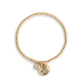 A gold beaded bracelet with a marigold round charm and light pink colored stone.