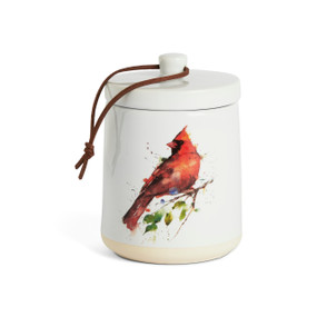 A white ceramic candle with a watercolor cardinal on the outside and a removable lid.