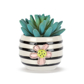 A mini white ceramic container with black stripes and a raised pink flower on the front. The container has an artificial succulent.