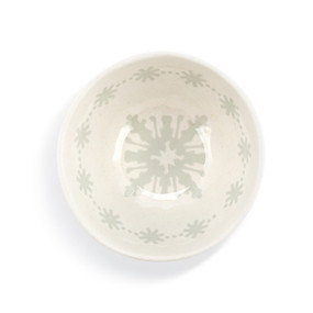 Top down view of a white and gray dip bowl with a snowflake pattern inside.