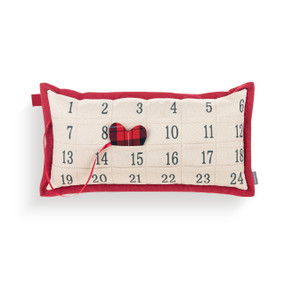 A rectangular cream and red pillow with 24 pockets to countdown to Christmas. There is a red and black plaid heart insert to put in the pockets.