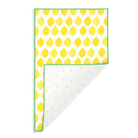 A rectangular double sided towel. One side is white with illustrated lemons and the other is white with yellow dots, displayed with the dot corner turned back.