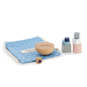 A balance game with different sizes and shapes of blocks that are meant to balance on a half circle wood block, displayed next to its blue fabric storage bag.