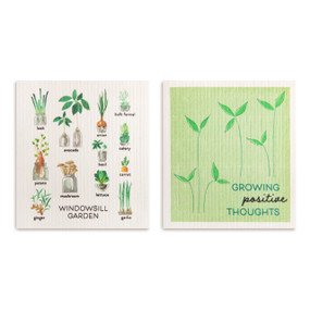 Two biodegradable dish cloths, one is green with the saying "Growing positive thoughts" and the other has illustrations of windowsill garden plants.