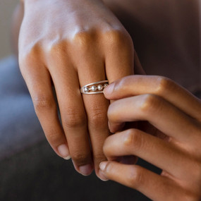 Close up of a woman's hands. She is wearing a silver ring with movable beads in the center.