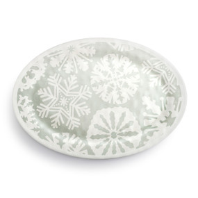 Top down view of a large gray oval melamine platter with large white snowflakes on the top.