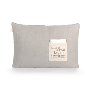 A light gray rectangular pillow with a cream fabric pocket on the front with the saying "this is a real tear-jerker". The pocket has a white fabric folded in it.