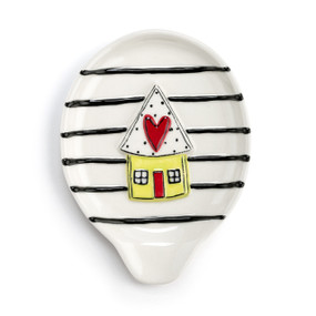 A cream stoneware spoon rest with black stripes and a raised house with a red heart on the roof.