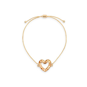 An adjustable gold chain bracelet with a heart shaped charm filled with small cream stones.