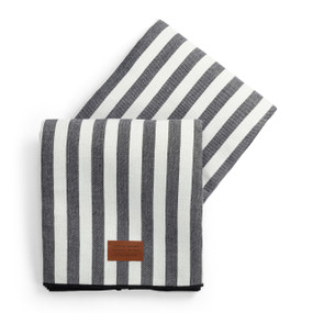 A large gray and white striped outdoor blanket with a small leather patch that says "Life is better outside in the sunshine".