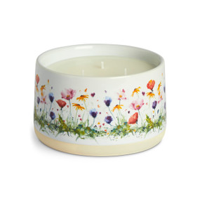 A three wick white ceramic candle with colorful watercolor wildflowers on the outside.
