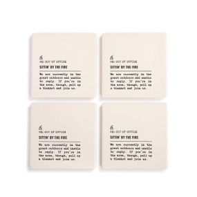 A set of four white ceramic coasters with the saying "RE: Out of Office Sittin' by the Fire" with a short write up about someone in the great outdoors.