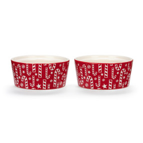 Two red ceramic ramekins with a white candy cane pattern on the outside, displayed at an angle to show the lip on the inside rim allowing them to stack.