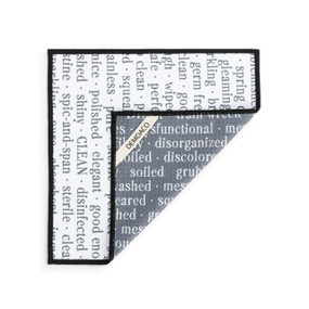 A double sided square dish cloth that is white on one side with words about cleanliness, displayed with the corner turned back.