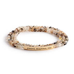 A multi-strand beaded bracelet in a mix of taupe with a gold metal bar that says "Strong, Beautiful, You".