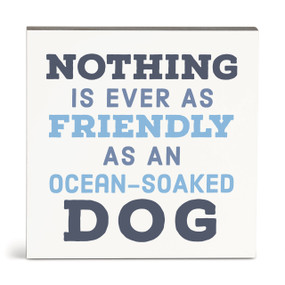 A square white wall art with the saying "Nothing is ever as friendly as an ocean-soaked dog".