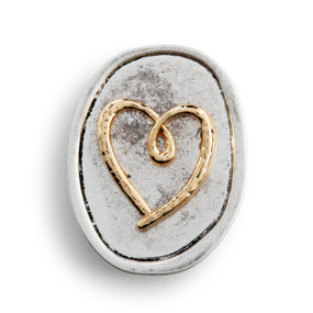 An oval silver metal token with a gold metal heart on it.