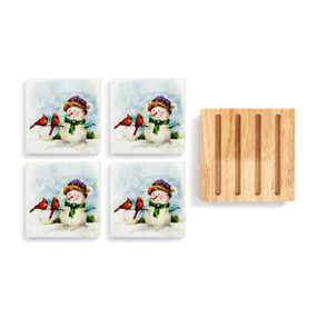 A set of 4 ceramic coasters with a watercolor image of a snowman and song birds next to a square wood board with 4 slots for holding the coasters.
