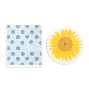 Two blue and yellow biodegradable dish cloths. One is round and looks like a sunflower and the other is blue polka dots and the saying "clean house happy house".