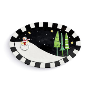 A black and white oval ceramic platter with a raised snowman and three green trees in the snow.