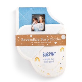A set of two burp cloths in blue and white. One is blue and the other has a rainbows and clouds illustration and says "Burpin' makes me feel good", displayed in a packaging band.