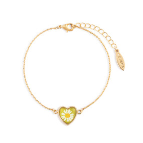 An adjustable gold chain bracelet with a heart shaped charm with a daisy on a yellow background.
