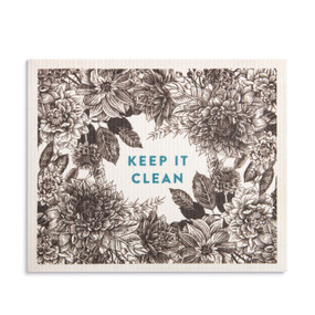 An oversized white biodegradable dish cloth with a black and white floral illustration and the saying "Keep It Clean".