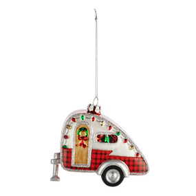 A red and white camper van ornament with holiday lights and a wreath on the door.