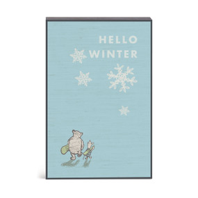 A blue wall art with an illustration of Pooh and Piglet carrying skis and the saying "Hello Winter".