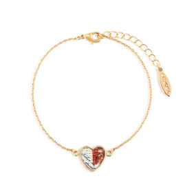 An adjustable gold chain bracelet with a heart shaped charm of stamped red and white postage.