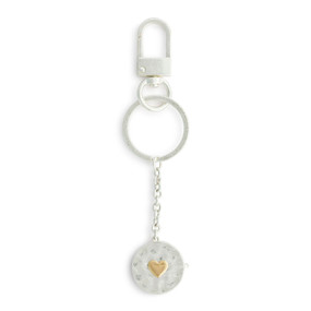 A silver metal keychain with a round silver locket attached. The locket has a gold heart in the center.